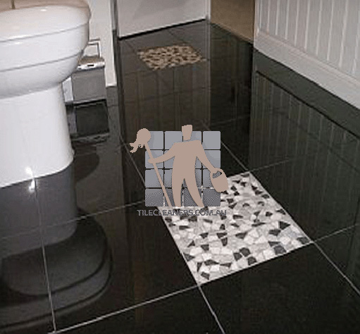 polished granite tile floor in bathroom black with one white tile Geelong