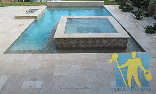 cleaned outdoor travertine tiles in a modern pool 
