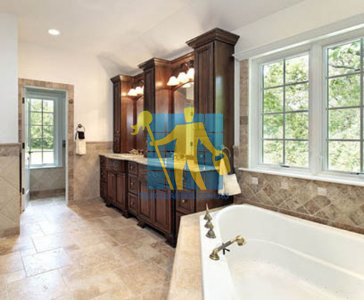 traditional bathroom with stone like tiles on floors and walls and bathtub Adelaide